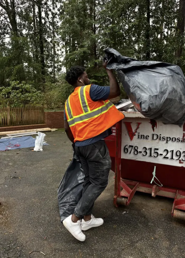 Express Moving Services mover hauling items to a dumpster